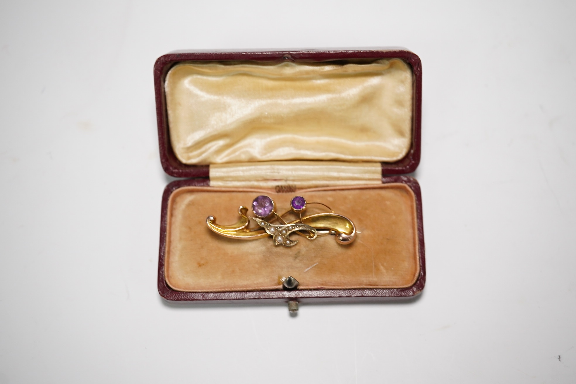 An Edwardian 9ct gold and gen set scroll brooch, 40mm, a yellow metal and gem set ring, a yellow metal overlaid fob seal and a modern coral bead necklace. Condition - poor to fair